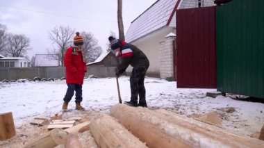 Kırsal kesimlerde kış etkinlikleri ve odun kesme ve oyun oynayan çocuklar