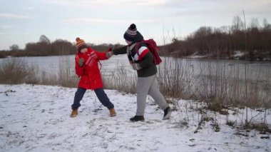 Çocuklar nehir kenarında kartopu savaşı yapıyor..