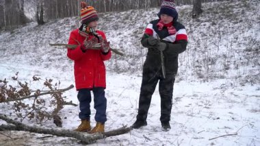 Çocuklar kışın dışarıda çubuk toplarlar..