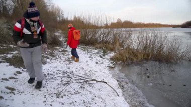 Çocuklar donmuş bir nehir kenarında oynuyorlar..