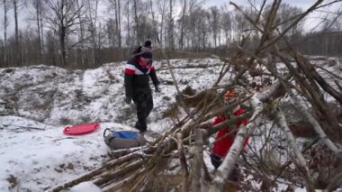 Çocuklar kışın tadını çıkarır, birlikte bir kar kalesi oluştururlar..