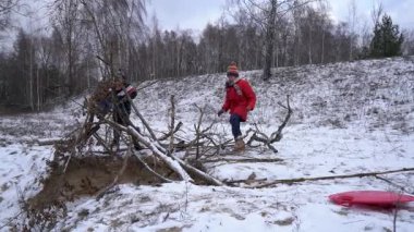 Çocuklar kışın kale yapmak için çubuk toplarlar..