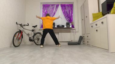 Enerjik dans hareketleri, içinde canlı bir dekor ve bisiklet bulunan küçük bir odada sergilendi. Dansçı iyimser müzikten zevk alırken yaratıcılık ve beceri ifade eder..