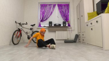 Genç dansçı, mor perdeler ve temiz dekorla süslenmiş şık bir odada etkileyici break dans hareketleri sergiliyor. Yetenek ve yaratıcılığı gösteren enerjik ritim boşluğu dolduruyor..