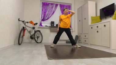 Genç bir dansçı, canlı perdelerle süslenmiş rahat bir dairede çağdaş dans yeteneklerini sergiliyor. Mekan bir bisiklet ve pratik için mükemmel neşeli bir atmosfer içeriyor..