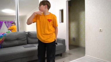 Genç bir çocuk dans yeteneklerini parlak ışıklı bir oturma odasında sergiliyor. Renkli dekorasyonlar neşe katarken, o coşku ve güvenle hareket ediyor..