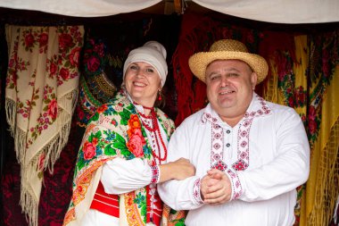 20 Ağustos 2022. Beyaz Rusya. Avtyuki köyü. Etnik kültürlerin kutlaması. Beyaz Rusya ulusal kostümlü bir adam ve bir kadın..