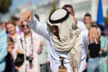 17 Eylül 2023. Beyaz Rusya. Gomel şehri. Farklı ırkların ve ulusların bayramı. Geleneksel giysiler içindeki bir Arap, şehrin sokaklarında dans ediyor..