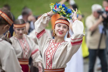 20 Ağustos 2022. Beyaz Rusya, Gomel. Ulusal Beyaz Rusya kültürlerinin kutlaması. Bir grup Belaruslu kız ellerinde çiçek çelengiyle ulusal giysiler içinde..