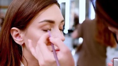 Güzel esmer bir kadın, güzellik salonunda renkli gözkapakları takar..