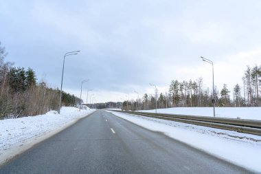 Karlı kış yolu. Avrupa ormanlarının soğuk manzarası. Finlandiya otoyolu gezisi. Yol ve yol karlı sokak gezisi. Sürücü.