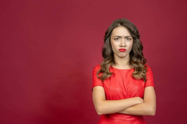 Kırmızı arka planda kırmızı elbiseli, sinirli esmer kadın..