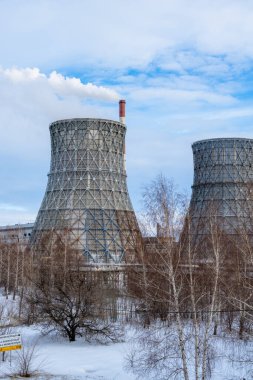 Gaz ve elektrik santralini soğuk bir kış gününde büyük borular, duman, buhar ve elektrik santralleriyle birleştirdi. Isı ve güç endüstrisinde doğal gaz kullanımı. Dikey video. Mavi, bulutlu gökyüzü.