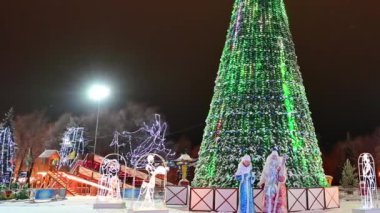Noel ağacı yanıp sönen ampullerle süslenmiş çelenkler, noel baloları, Noel Baba, kar yağan kar kızıyla süslenmiş. Mutlu yıllar festival havası. Pozitif duygu.