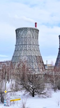 Gaz ve elektrik santralini soğuk bir kış gününde büyük borular, duman, buhar ve elektrik santralleriyle birleştirdi. Isı ve güç endüstrisinde doğal gaz kullanımı. Mavi, bulutlu gökyüzü.