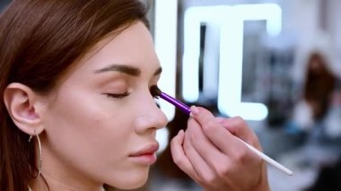 Güzel esmer bir kadın, güzellik salonunda renkli gözkapakları takar..