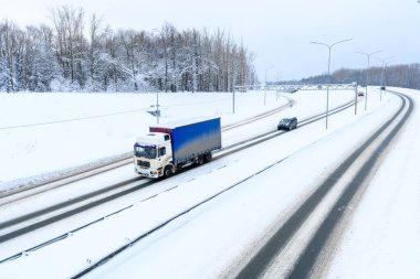 Ulyanovsk, Rusya - 13 Şubat 2022: Yarı karavan, yarı kamyon, traktör ünitesi ve yük taşımak için yarı römork. Kargo taşımacılığı sert kış koşullarında kaygan, buzlu ve karlı yollarda.