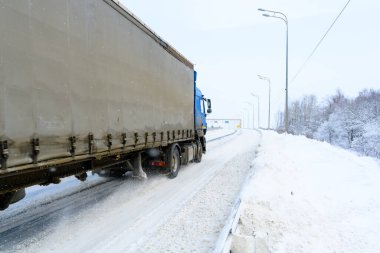Yarı karavan kamyonu, yarı kamyon, traktör ünitesi ve yük taşımak için yarı karavan. Kargo taşımacılığı sert kış koşullarında kaygan, buzlu ve karlı yollarda.