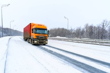 Ulyanovsk, Rusya - 13 Şubat 2022: Yarı karavan, yarı kamyon, traktör ünitesi ve yük taşımak için yarı römork. Kargo taşımacılığı sert kış koşullarında kaygan, buzlu ve karlı yollarda.