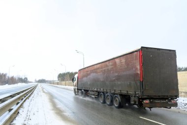 Yarı karavan kamyonu, yarı kamyon, traktör ünitesi ve yük taşımak için yarı karavan. Kargo taşımacılığı sert kış koşullarında kaygan, buzlu ve karlı yollarda.