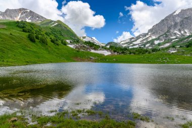 Alp Dağları 'ndaki göl. Dağları olan güzel bir manzara, yeşil çimenli çayırlar ve ilkbaharda yürüyüş yolu..