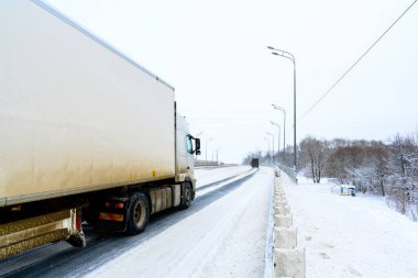 Ulyanovsk, Rusya - 13 Şubat 2022: Yarı karavan, yarı kamyon, traktör ünitesi ve yük taşımak için yarı römork. Kargo taşımacılığı sert kış koşullarında kaygan, buzlu ve karlı yollarda.