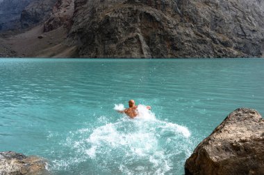 Tacikistan dağlarında yüzen bir turist. Fan Dağları.