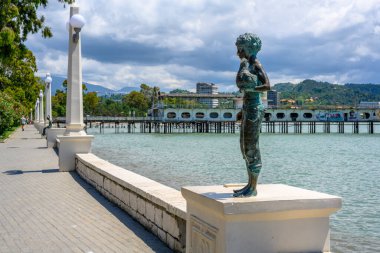 Sukhumi, Abhazya, Gürcistan - 03 Temmuz 2022: Arsız çocuğun tavuklu heykeli manzaralı deniz manzarası.