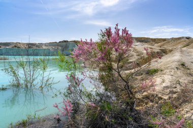 Mavi göl, katmanlı dağlar, kireçtaşından tepeler, Batı Kazakistan bölgesindeki Melovye Gorki köyündeki kireçtaşı ocağı..