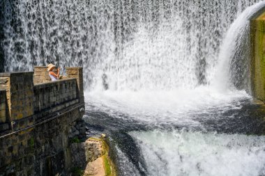 Yeni Athos, Abhazya, Gürcistan - 4 Temmuz 2022: Güneşli bir yaz gününde güzel yapay şelale ve turistler.
