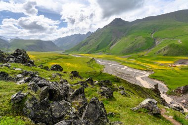 Kyzylkol nehri ve Emmanuel açıklığı manzarası Elbrus bölgesinde kamp yaparken ön planda büyük benekli taşlar vardı. Prielbrusye, Kuzey Kafkasya, Rusya.