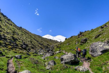 Büyük sırt çantalı dağcıların Kuzey Kafkasya 'daki Elbrus Dağı' nın zirvesine giden yürüyüş yolu manzarası. Dağ tırmanışı.