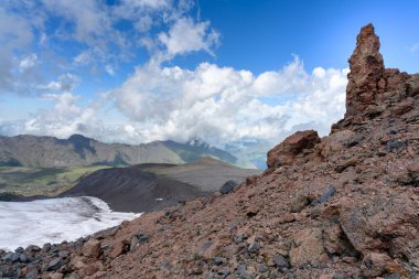 Ay açıklığındaki muhteşem manzara yürüyüş yolu ve ön plandaki renkli taşlarla birlikte. Elbrus bölgesi, Kuzey Kafkasya, Rusya.