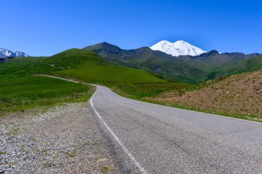 Elbrus Dağı 'nın zirvesi, yol, yeşil çayırlar, dağ ve Kafkas sırtı. Kuzey Kafkasya, Rusya.