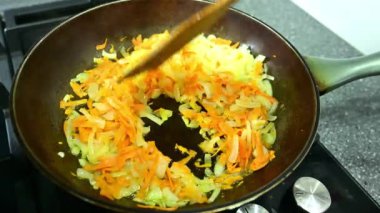 Doğranmış soğan ve rendelenmiş havuçlar tavada cızırdar, aromaları mutfağı doldurur. Bir spatula karışımı karıştırır, yemek pişirmeyi bile garantiler ve lezzetli bir altın-kahverengi renk.