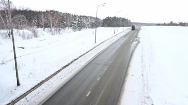 Ulyanovsk, Rusya - 13 Şubat 2022: karavan, traktör ünitesi ve yük taşımak için yarı römork. Kargo taşımacılığı sert kış koşullarında kaygan, buzlu ve karlı yollarda.