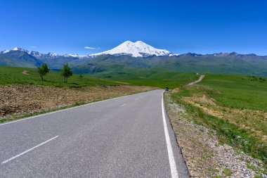 Elbrus Dağı 'nın zirvesi, yol, yeşil çayırlar, dağ ve Kafkas sırtı. Kuzey Kafkasya, Rusya.