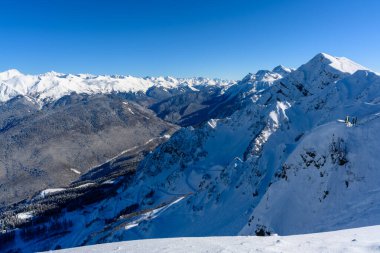 Karla kaplı tepeleri ve vadisi olan bir kış dağı manzarası. Doğal güzellik ve huzurlu bir atmosfer..