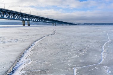 Ulyanovsk, Rusya - 08 Şubat 2025: Volga Nehri 'nin en geniş noktasındaki uçsuz bucaksız buz zeminine yakın plan Başkanlık Köprüsü. Avrupa 'nın en uzun köprüsü..