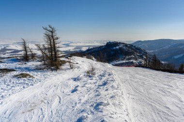 Kayak pisti, Ural Dağları 'nın pitoresk manzarasına karşı ahşap bir çitle sınırlı. Abzakovo köyünün yakınında güneşli, soğuk bir kış günü..