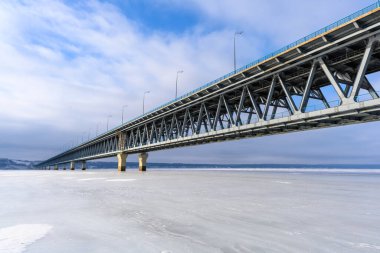 Ulyanovsk, Rusya - 08 Şubat 2025: Volga Nehri 'nin en geniş noktasındaki uçsuz bucaksız buz zeminine yakın plan Başkanlık Köprüsü. Avrupa 'nın en uzun köprüsü..