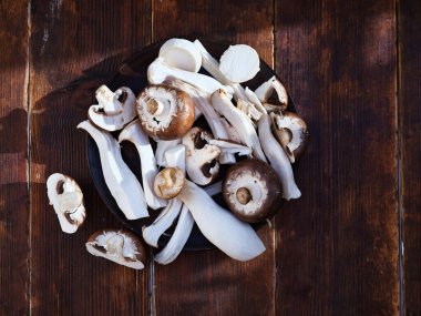 Top view various mushrooms cut on a plate