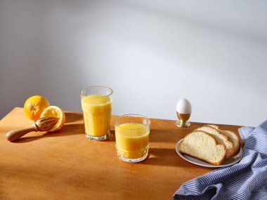 Breakfast with a glass of fresh-pressed orange juice and some slices of brioche bread