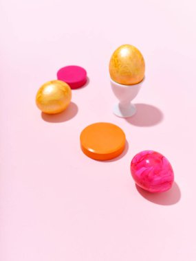 Renkli kırmızı ve altın renkli paskalya yumurtaları ve parlak pembe arka planı olan yaratıcı bir düzen. Festival içeriği için bir şablon