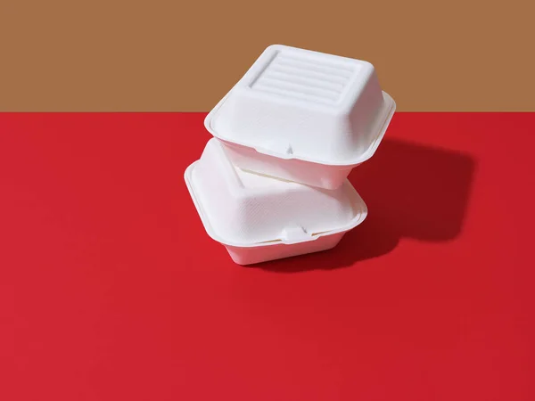 Burger take away boxes on red background with copy space