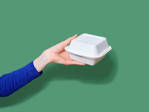Weibliche Hand Hält Lebensmittelbehälter Für Burger Zum Mitnehmen Auf Grünem — Stockfoto