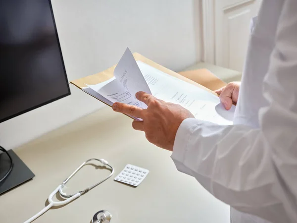 Man Medische Professional Gaat Door Het Papierwerk Van Patiënt Een Stockfoto