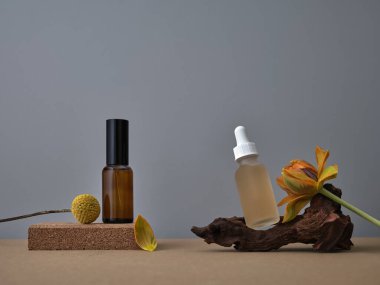 Lüks cilt bakımı seti, kahverengi ve gri arka planda boş güzellik ürünleri şişeleri. Çeşitli aksesuarlarla ürün çekimi. Serum, el kremi, nemlendirici..