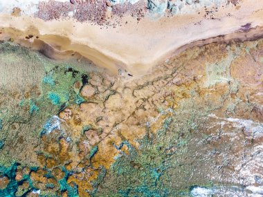 Baharda boş bir plajda yalnız bir adamın hava görüntüsü. Sardunya, İtalya