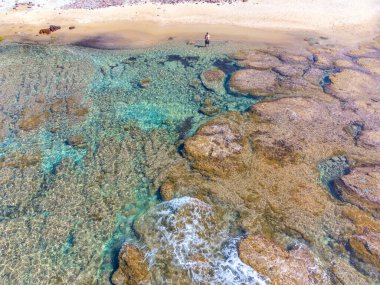 Baharda sahilde yalnız bir adamın hava görüntüsü. Sardunya, İtalya